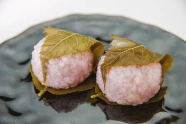 Bean paste rice cake wrapped in a cherry leaf on black dish