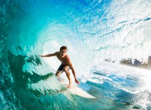 Close-up of a surfer riding a large blue wave