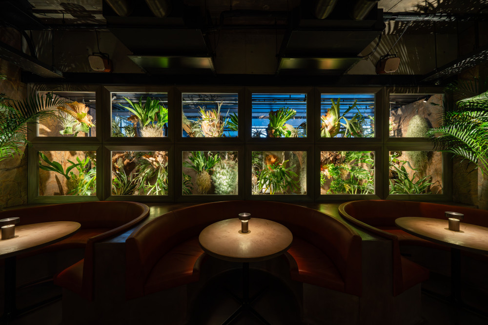 ful kyoto tables and sofas arranged in front of a wall of plants