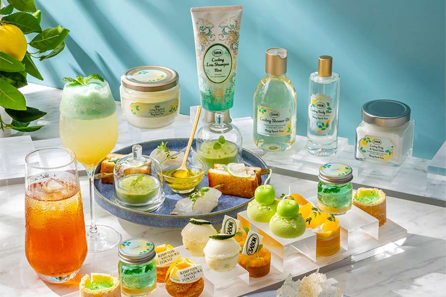 Small green and yellow sweets and cakes alongside summery orange drinks, part of the afternoon tea set at Kimpton Shinjuku Tokyo.