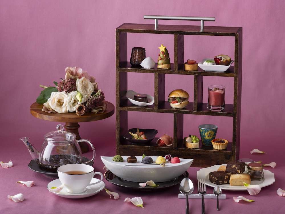 Small Christmas Tree-shaped desserts, pork sliders, and cookies are arranged on a tall wooden case for Mitsui Garden Hotel Yokohama's Christmas-themed Afternoon Tea spread.